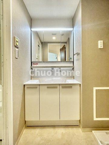 なぎさニュータウン4号棟の独立洗面台|【洗面化粧台】洗面化粧台には三面鏡を採用。身だしなみを整えやすい事はもちろんですが、鏡の後ろに収納スペースを設ける事により、散らかりやすい洗面スペースをすっきりさせる事が出来るのも嬉しいですね