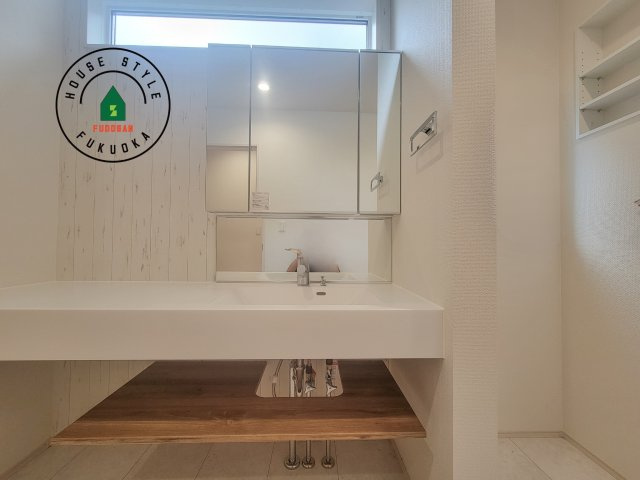 福岡市東区美和台5丁目第2-3棟（2号棟）の内観：施工例|毎日使うものだから清潔な空間を保ちたい水回り。洗面にはそんな願いを解消させてくれる収納アイデアが満載です。三面鏡の裏側にはキャビネットが現れ小物から背の高い物まで収納できます。