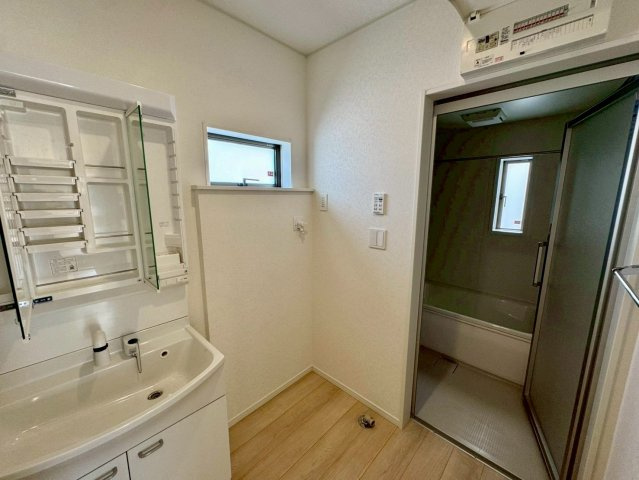 クレイドルガーデンうるま市塩屋 第１・3号棟の独立洗面台|ハンドシャワー付き洗面化粧台＆洗濯機置場から浴室への動線