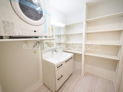【洗面所】 | 奈良市法蓮町の新築一戸建 全２区画 ３ | 現地写真（１号地洗面）シャワー付き洗面化粧台、雨の日も安心のガス衣類乾燥機【乾太くん】を設置しました