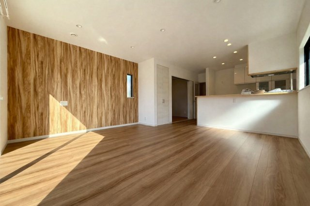 高知市福井町A号地 新築一戸建て　の居間・リビング|陽だまりが心地よい広々LDK。木目のアクセントが映える、家族でくつろぐ上質空間。