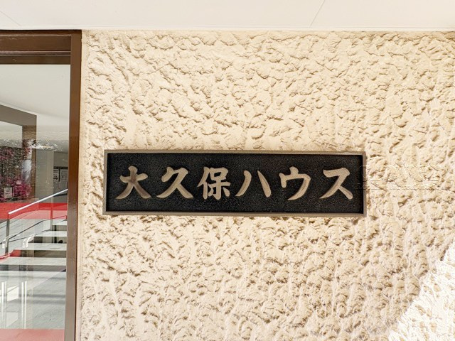 【現況写真】 | 大久保ハウス | エントランスに掲げられた、マンション名を示す館銘板。さほど激しく主張はしませんが、しっかりと掲示されています。～即日のご見学可能～　お問合せはお気軽にどうぞ。