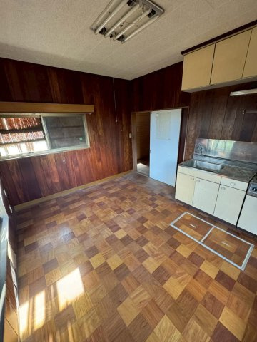 レトロモダンな海辺の邸宅～銚子市海鹿島町～のキッチン|床がレトロモダンなダイニング。深みのあるウッド壁が、カフェのようなおしゃれな空間への改造を予感させま