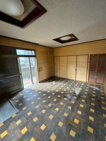 レトロモダンな海辺の邸宅～銚子市海鹿島町～の居間・リビング|二面採光で開放感あふれる広々リビング。木目調の壁が落ち着いた雰囲気を醸し出し、家族の団らんに最適です