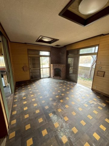 レトロモダンな海辺の邸宅～銚子市海鹿島町～の居間・リビング|レンガ造りの暖炉風コーナー。個性的な床のパターンと相まって、山荘のような温かみのあるリビング。民泊と