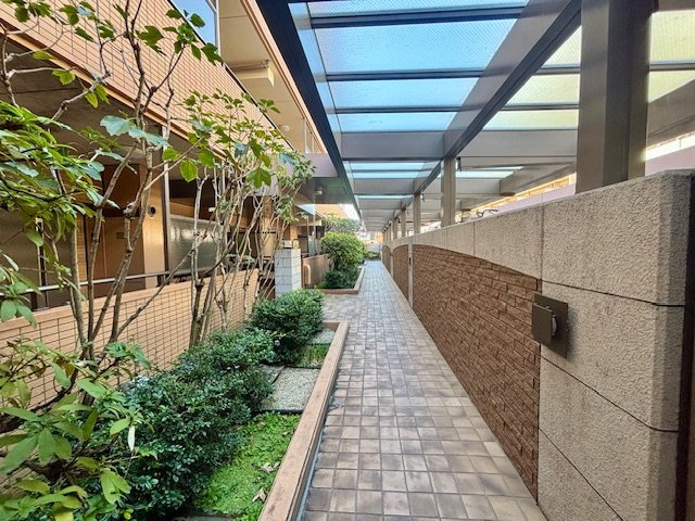 コスモシティ市川イーストのその他共用部分|1階にある屋根付き外部廊下には、緑豊かな植栽のスペースがあります。2026年3月撮影