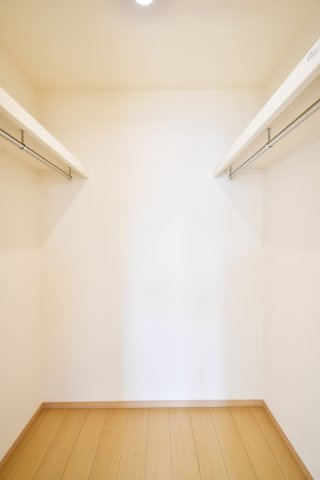 久喜青毛1丁目6番　全4棟　D号棟の収納|7帖の主寝室に備わる、大容量のWICです。ハンガーパイプと枕棚付きで、季節物の衣類や大型バッグも一箇所に集約可能。お部屋を常に美しく保ち、日々のコーディネートが楽しくなる、主役級の収納空間です。