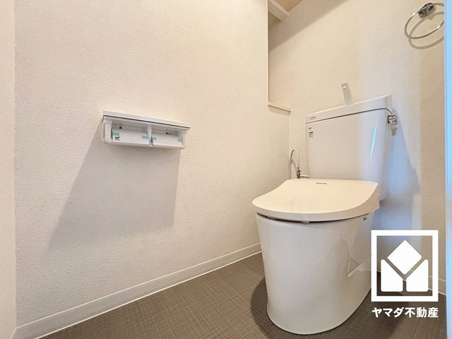 ライオンズマンション尼崎ガーデンシティのトイレ|明るく清潔感溢れるトイレです。2連トイレットペーパーホルダーなのでお取替えの手間が軽減できます。トイレットペーパーのストックや、消耗品置き場、小物置きなどとしてもお使いいただける棚がございます。