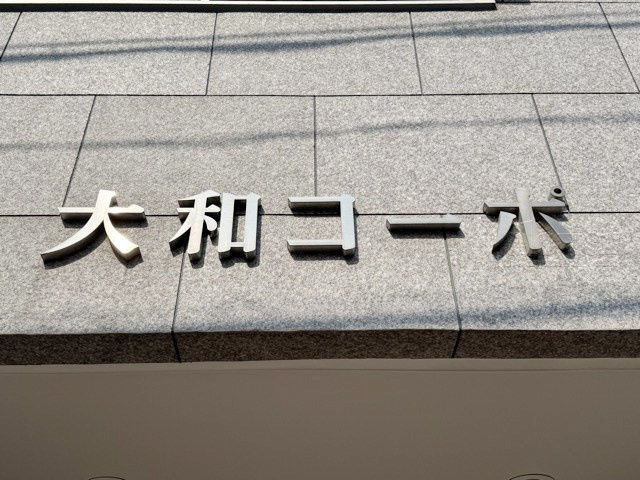 【現況写真】 | 大和コーポ | エントランスに掲げられた、マンション名を示す館銘板。さほど激しく主張はしませんが、しっかりと掲示されています。～即日のご見学可能～　お問合せはお気軽にどうぞ。