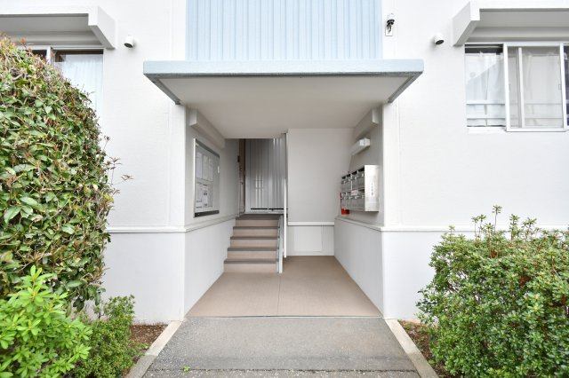 上尾ハウス2号棟|落ち着いた色調のタイル貼りが印象的な外観。エントランス周辺はきれいに整備されており、管理体制の良さがうかがえます。住まいの顔として、住まう人を優雅に迎え入れ、日々の暮らしに安心感を与えてくれます。