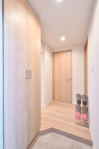 上尾ハウス2号棟の玄関|木の温もりを感じるナチュラルな内装が魅力。廊下まで統一されたデザインが、住まい全体の広がりを演出します。段差の少ない上がり框や、整理整頓をサポートする大容量収納など、日々の暮らしに配慮した設計です。