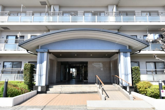 ベルドゥムール春日部東|植栽の緑が美しく整えられた、品格漂うアプローチ。平坦な道のりでベビーカーや車椅子での移動もスムーズです。毎日を気持ちよく迎え、住まう誇りを感じさせてくれる開放的な外観デザインです。