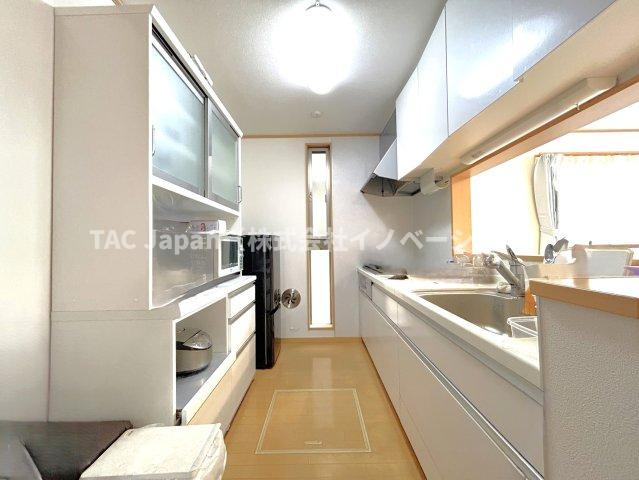 川口市朝日の邸宅のキッチン|会話が弾む対面型キッチン。後ろにはお洒落な食器類を余裕で収納できるスペースがあります。