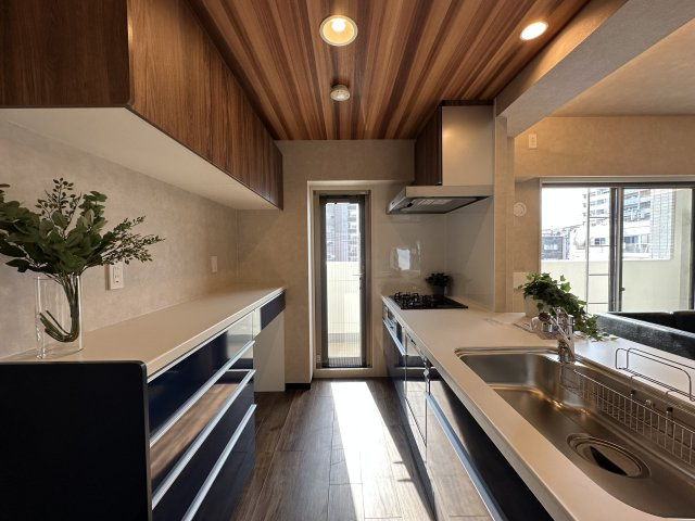 ドルフ灘ヴェールデュランのキッチン|天井には木目クロスを採用し、温かみのある落ち着いたキッチン空間に。毎日の料理時間を心地よく演出します