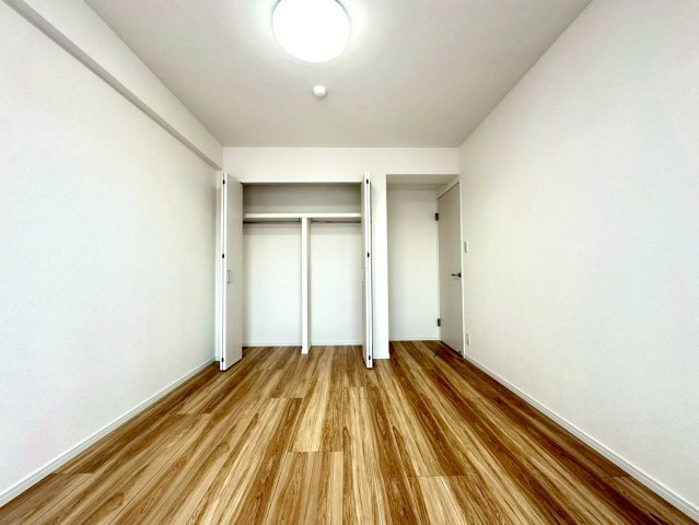 サンライズ片倉の洋室|木目の美しいフローリングが印象的な洋室。十分な広さと収納を備え、落ち着いたプライベート空間として快適にお使いいただけます。