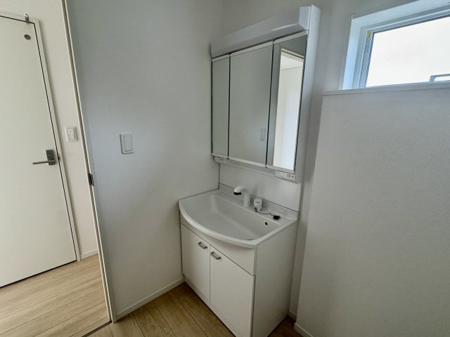 阪南市箱作第２　1号棟の独立洗面台|三面鏡の裏に隠された大型キャビネットが、出しっぱなしになりがちな小物をスマートに収納します。