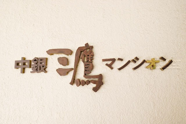 【現況写真】 | 中銀三鷹マンシオン | エントランスに掲げられた、マンション名を示す館銘板。さほど激しく主張はしませんが、しっかりと掲示されています。～即日のご見学可能～　お問合せはお気軽にどうぞ。
