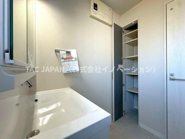 北区岩淵町の良邸の洗面所|大型の洗濯機を置いても余裕が感じられる脱衣スペースにはお洒落な洗面ユニットを設置。着替えやタオル、洗剤の買い置きなどを置いておける便利なリネン庫を完備しています。