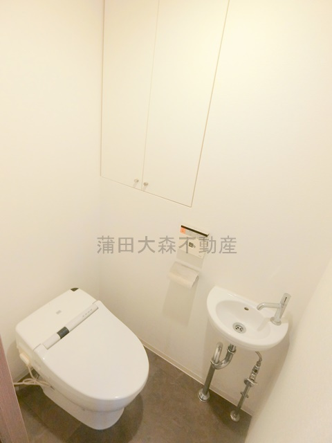 イプセ蒲田WESTのトイレ|棚と温水洗浄便座と手洗い場付きのトイレ