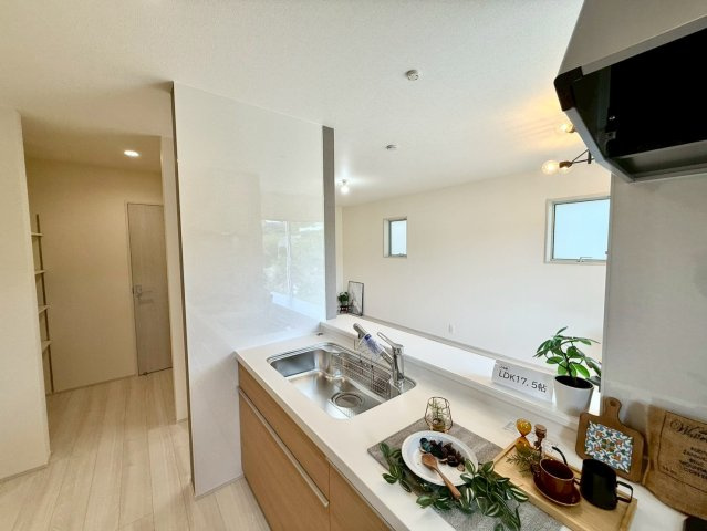 リーブルガーデン八重瀬町玻名城 第２・２号棟のキッチン|キッチン横には大容量の収納スペースがあり、洗剤や日用品のストックが料理の合間にサッと取り出せる動線に◎