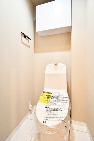 日商岩井第二春日部マンションのトイレ|トイレ：奥行きにゆとりがあり、圧迫感の少ないトイレスペース。吊戸棚付きで、トイレットペーパーなどの備品補充も楽々行えます。掃除用具をしまうと清潔感も消す事ができ、イマドキなお部屋にできます。