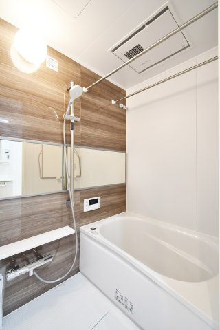 日商岩井第二春日部マンションの浴室|シックで上品さを感じるバスルームはまるでホテルのような仕上がり。日常から解放できる癒しの空間となります。木目がアクセントになっております！新品ですのでご入居後から気持ちよく入浴頂けます。
