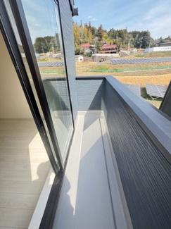 【バルコニー】 | 東広島市高屋町高屋東（全2区画）2号棟 | バルコニー壁面には物干し金物を設置。プライバシーに配慮した高さの壁があり、外部からの視線を遮りつつ、光と風を取り込みます。主寝室から直接出入りできる動線で、布団干しなどの家事負担も軽減されます。