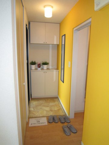 クレストコトーA棟の玄関|明るい色のアクセントクロスを利用した玄関です。