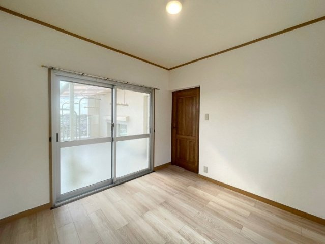 山手台4丁目の洋室|木目のフローリングが暖かみのある室内に。明るい寝室で心地のいい朝を迎えられそう。