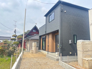 【外観】 | 東広島市八本松飯田6丁目（全2区画）1号棟　 | 黒のスタイリッシュな外壁に木目調のアクセントを施した、モダンな外観デザイン。2階建ての独立性が保たれた設計です。前面には駐車スペースとしての広さも確保されており、自家用車の所有にも適しています。