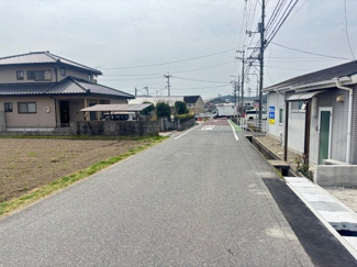 【前面道路含む現地写真】 | 東広島市八本松飯田6丁目（全2区画）1号棟　 | 物件前面は平坦な道路に面しており、視認性も良くスムーズな入出庫が可能です。周辺は戸建住宅や田畑が広がる落ち着いた街並みで、開放感のある住環境が保たれています。