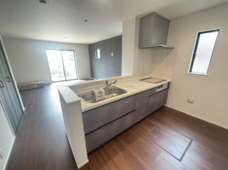 【キッチン】 | 東広島市八本松飯田6丁目（全2区画）1号棟　 | リビングを見渡せる対面式のシステムキッチン。家事をしながら家族との会話を楽しめます。背後には窓があり、手元を明るく照らすとともに換気もしやすい設計です。