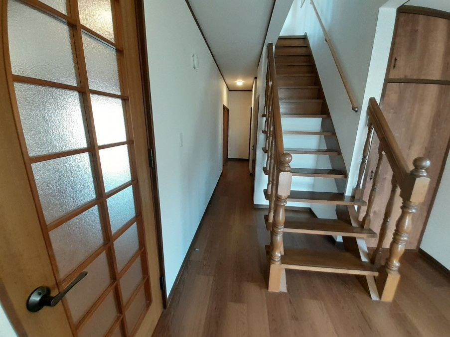 １階玄関から入った廊下部分です。階段の右と階段下が収納部分になっております。左側がリビングへと繋がります。