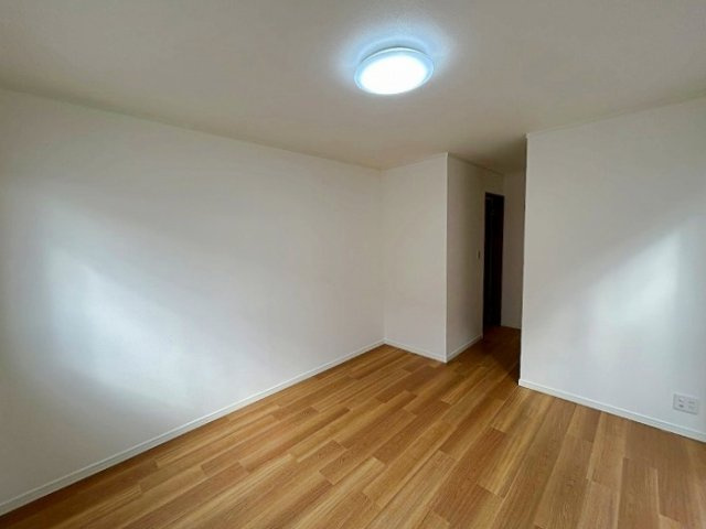 北大樋町の洋室|木目のフローリングが暖かみのある室内に。明るい寝室で心地のいい朝を迎えられそう。