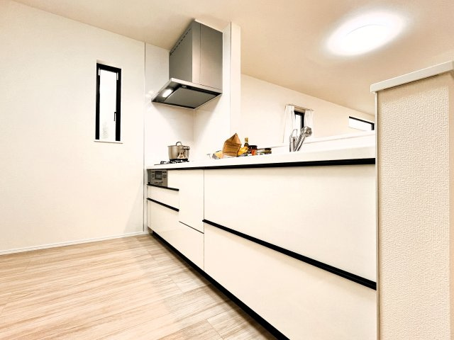 足立区花畑４丁目　新築分譲住宅　全５棟のキッチン|【システムキッチン】豊富な収納はもちろん、大型シンクに３口グリル付きコンロ・浄水器など使いやすさ重視の対面式システムキッチン。ご家族と楽しく会話をしながら料理もできます♪