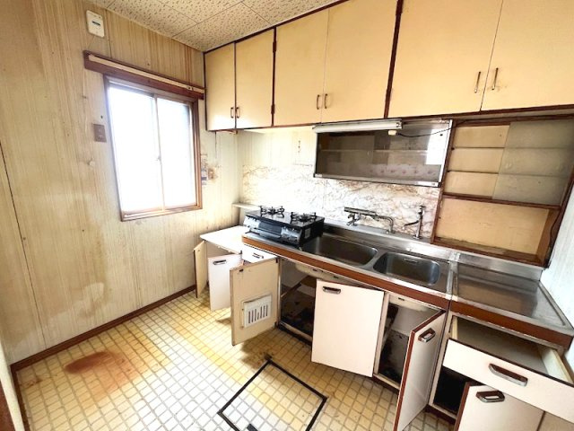 北見市寿町４丁目４番２１号　中古売家のキッチン|キッチンは、吊戸棚やキャビネットなど、豊富な収納スペースあり、コンロやシンク台が天板で継ぎ目なく一体化しているため、掃除がしやすいです。