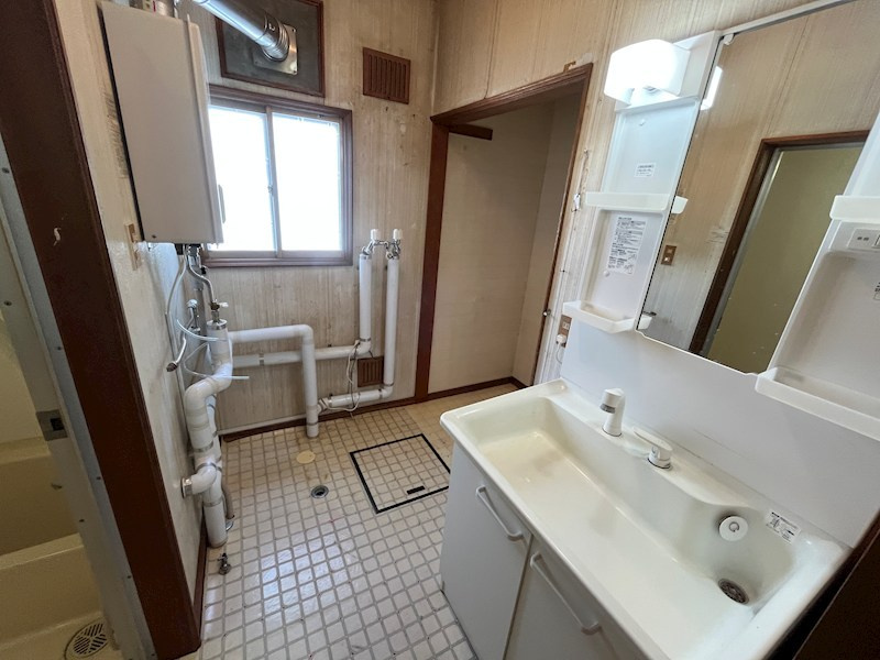 北見市寿町４丁目４番２１号　中古売家の脱衣所|洗面所と脱衣室を仕きる壁や扉がないことで、洗面台と洗濯機の間にカウンターを設けることができ、カウンター下には、家族分のタオルや下着、ゴミ箱などを収納できます。