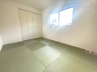 【和室】 | 東広島市八本松飯田4丁目（全4区画）No2 | 6.5帖の洋風和室は、モダンな縁なし畳を採用。大容量の押入を備えており、布団や季節物の収納も安心です。リビングとフラットに繋がる設計のため、お子様の遊び場や家事スペースとしても多目的に活用できます。