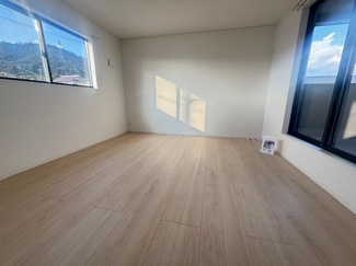 【洋室】 | 東広島市八本松飯田4丁目（全4区画）No2 | 8.5帖の主寝室は、バルコニーに面した明るい空間です。2面採光を確保しており、日当たり・通風共に良好。大型のクローゼットを備えているため、衣類や寝具もすっきりと収納でき、居住スペースを広く使えます。