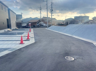 【前面道路含む現地写真】 | 東広島市八本松飯田4丁目（全4区画）No2 | 幅員にゆとりがある前面道路は、舗装も新しく整然とした街並みです。視界を遮る高い建物が少なく、開放的な住環境。車の出し入れもスムーズに行える広さが確保されています。