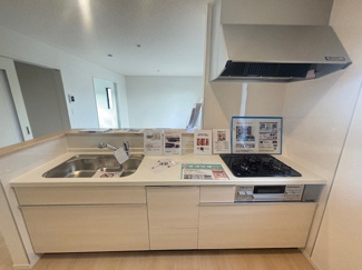 【キッチン】 | 東広島市八本松飯田4丁目（全4区画）No2 | 調理スペースが広く確保された、使い勝手の良いシステムキッチンです。リビング全体を見渡せる対面式。床下収納も備えており、ストック品や普段使わない調理器具の保管にも重宝します。