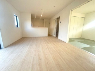 【居間・リビング】 | 東広島市八本松飯田4丁目（全4区画）No2 | 15.7帖のLDKは、明るい色調のフローリングが空間をより広く見せています。隣接する洋風和室の扉を開放すれば、22帖超の広々とした空間に。対面式キッチンのため、家事をしながら家族との会話も楽しめます。