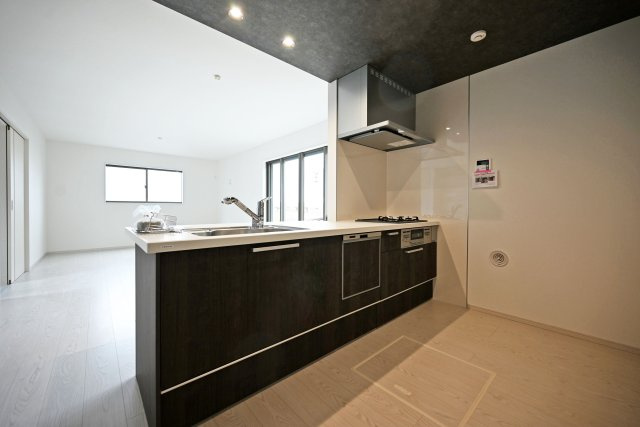 テラシエ花屋敷つつじガ丘新築一戸建て│4LDK+並列駐車2台可のキッチン|1階LDKをキッチン越しに撮影した現地内観写真です。 広くて使いやすいキッチンは折り下げ天井を採用しており、 オシャレな空間に仕上がりました。