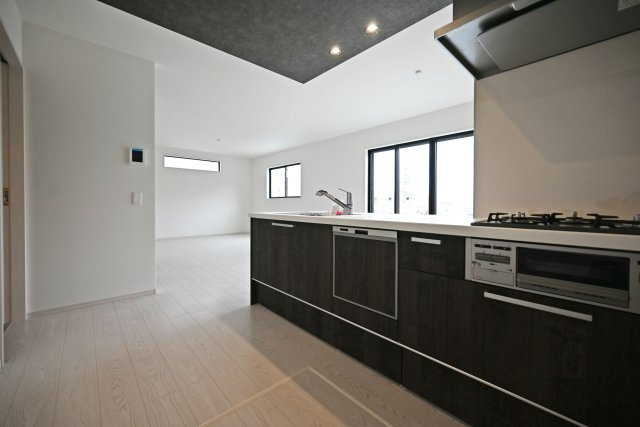 テラシエ花屋敷つつじガ丘新築一戸建て│4LDK+並列駐車2台可のキッチン|1階キッチン奥側から撮影した写真です。浄水器一体型水栓、フラット整流板、食器洗い乾燥機などの充実した設備内容です。