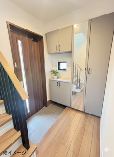 【玄関】 | 安芸区中野6丁目（中野東駅）【外構込み価格♪】NO1　 | 姿見付きの大型シューズボックスを完備した玄関。散らかりがちな靴をスッキリ収納でき、お出かけ前の身だしなみチェックもスムーズです。小窓からの採光で明るい空間となっています。