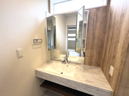 泉南市新家サングリーン新築住宅の独立洗面台|三面鏡の裏に隠された大型キャビネットが、出しっぱなしになりがちな小物をスマートに収納します。