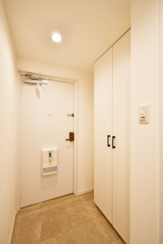 大宮公園ロジュマンの玄関|白を基調とした清潔感溢れる玄関。天井高まである大容量のシューズボックス付きで、家族全員の靴をすっきり収納。人感センサーライトが帰宅を優しく迎え、夜間の帰宅や荷物が多い時もスイッチ要らずで快適です。