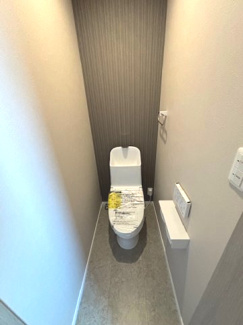 【トイレ】 | 中区江波栄町　1区画 | 各階に設置されたトイレは、それぞれ異なるアクセントクロスで個性を演出。TOTO製の温水洗浄便座を採用し、スタイリッシュな壁付けリモコンで操作性も良好です。毎日使う場所だからこそのこだわりが光ります。
