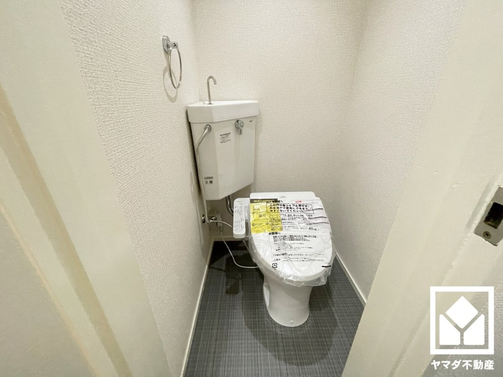 夙川カームマンションのトイレ|明るく清潔感溢れるトイレです。タオル掛けやペーパーホルダーが設置されています。