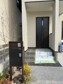 【玄関】 | 廿日市市上平良字郡塚（廿日市市役所前電停）1区画 | 重厚感のある玄関ドアが印象的なアプローチ。不在時に便利な宅配ボックス付きの機能門柱を設置しています。ポーチ部分は屋根があるため、雨の日の出入りや荷物の積み下ろしにも配慮されています。